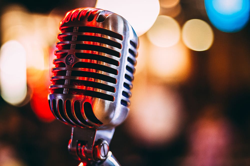 Photo by israel palacio on Unsplash A close up of an old microphone with lights in the background