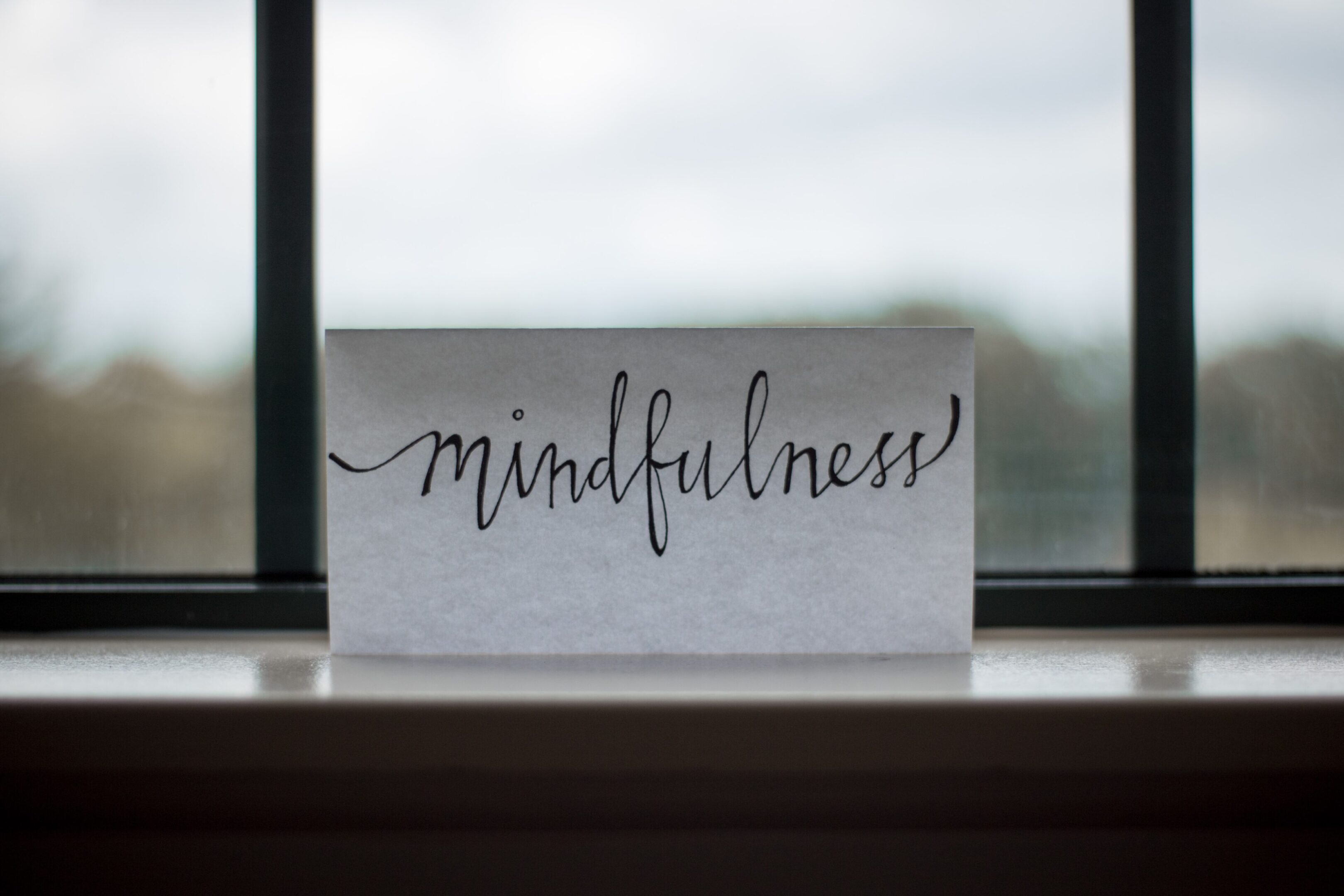 Photo by Lesly Juarez on Unsplash A sign that says mindfulness on the window sill.