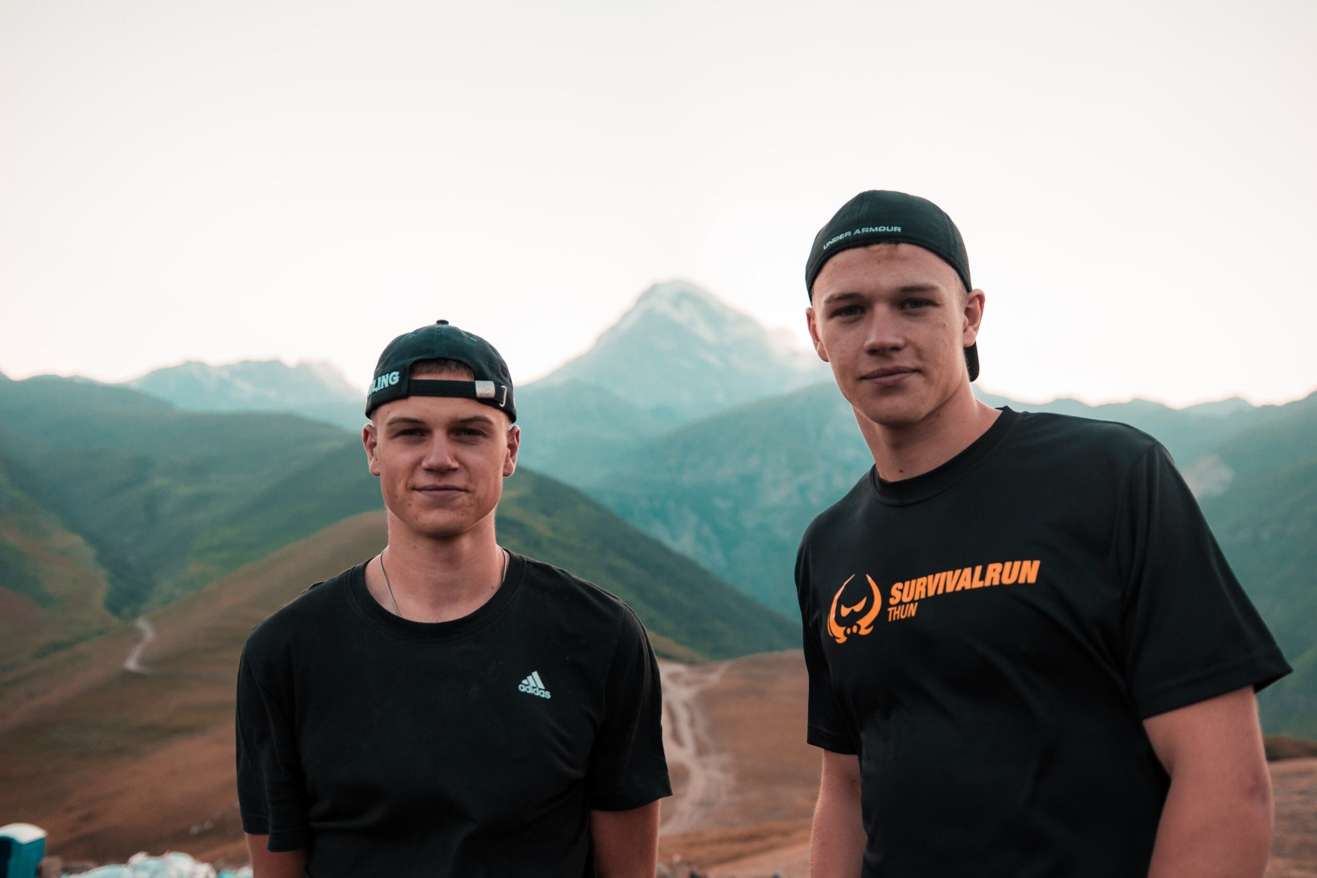 jairph-Older Brothers | Twins-unsplash Two men standing in front of a mountain range.