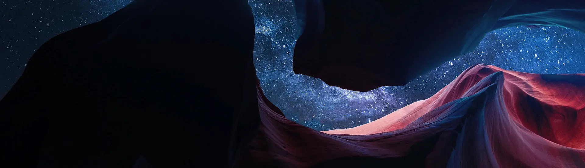 A person is standing in the dark with their arms crossed.